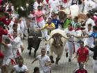 Runners avoid the bulls as they run through the streets