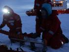 Carrie and Michael slide an ice core out of the coring device in order to take notes on its appearance (Photo: Katie Gavenus)