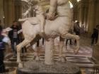 Cupid jokingly riding the back of a centaur. 