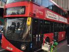 Fancy modern red double-decker red bus versus self-service bicycle