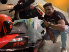My friend carrying eight bags of ice with two passengers on his motorcycle!