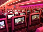 Mostly empty plane cabin bathed in pre-departure fuchsia light