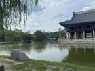 This building is for hosting parties and meetings. It is surrounded by water and beautiful plants. 