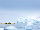 Kayaking past large icebergs