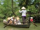 My friends and I traveling along the Mekong River with rice hats to protect us from the sun