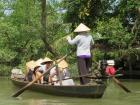 My friends and I traveling along the Mekong River with rice hats to protect us from the sun