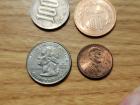 Japanese ￥100 and ￥10 coins compared to a U.S. quarter and penny