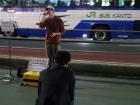 A singer performing outside of Shinjuku Station at night