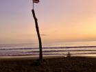 Costa Rica summed up in one picture: the Costa Rican flag and a surfer on the beach, watching the sunset