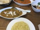 Trying Indian food such as tikka masala and palak paneer at a restaurant in Anam 