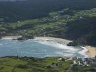 Here you can see the contrasts between the blue of the water, the green of the landscape and the white sand with the cliffs behind 