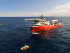 Three eight meter long uncrewed ships operating near a large 100 meter long crewed ship