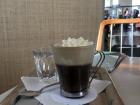 Einspäner coffee in a clear glass with metal handle. 