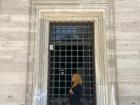 I am standing under one of the grand windows of a mosque, which is a worship place for Muslims