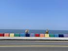 My friend sitting with a statue at the Jeju rainbow coastal road