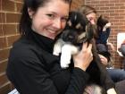 A 2018 photo of Justine taking a break from vet school with a puppy