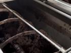 The olives are mashed up in a big tub