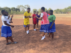 The girls jump high off the ground in a game of "Ampe"