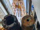 The drilling pipes we use to reach the ocean floors and take samples; Behind them is the large tower, called a derrick, that holds the pipes up 