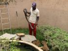Tour guide taking python out of the cylinder-shaped cage 