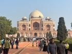 Crowds move steadily through the grounds of a historic Delhi monument
