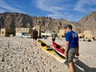 We carry our kayaks ashore through a coastal village