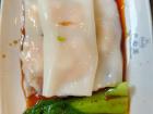 Cheung fun, a Chinese dim sum dish featuring steamed rice noodle wrapped around shrimp, served with a sweet and salty soy sauce