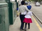 A cute moment between a mother and her daugher walking in the streets of Peru