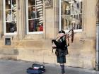 A Scottish man playing the bagpipes on a street in Edinburgh, Scotland 