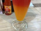 This is a drink with watermelon juice on the top and orange juice on the bottom
