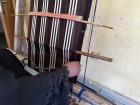 Mrs. Ovavu finishes pulling through the weft and will begin to weave the second layer which includes turning the Okaha flat, removing it, and inserting it underneath the Ochi-aya (pink stick).