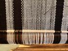 In weaving, the sticks come from plants and trees. The thin one is from a piece of a traditional Nigerian broom which is made from the midribs of coconut palm and oil palm trees. 