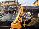 A Keke driver navigating through heavy traffic in Lagos.