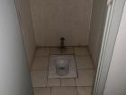 "Toilets" as found in the bathroom stalls of the largest football stadium in the country: Bingu National Stadium (Note: you step on the pedal near the wall to flush)