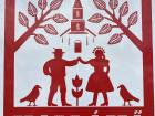 Hollókő sign depicting their traditional cultural heritage, including the embroidery patterned text, the tulip, the original church, clothes and the crows 