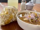Encebollado - a tasty fish stew topped with red onion. It always comes with a bag of popcorn and plantain chips to sprinkle on top.