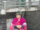 A fleeting view from the car window. An indigenous lady in traditional clothing waiting for a bus.