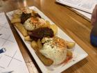These are "patatas bravas" which are a very popular dish in Spain. They are crispy potato wedges covered in different sauces. This one was marinara and an herb aioli!