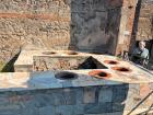 The ruins of what a "fast food" store looked like in Pompeii, the food being placed into round "bowls" in the counter, which would help keep the food warm