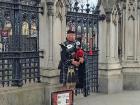 A gentleman playing bagpipes right in front of Big Ben