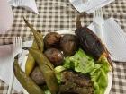 A plate of pachamanca featuring beans, potatoes, a plantain, pork and a salad. 