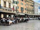 Many people sitting and enjoying fresh, tasty Italian food and drinks at Piazza Bra