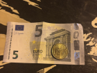This is a picture of both a euro bill and a euro coin