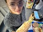 I am eating one of my favorite snacks, an elote, from a vendor in the center of town