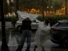 Hillary and Arden standing in the rain with trash bags
