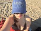 Mikayla in a red skirt sitting on the sand