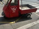A tiny Piaggio Ape parked on a Roman street; small but powerful, perfect for delivering goods through narrow alleys
