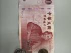 A NT$100 bill and coins for NT$50, NT$10, and NT$1