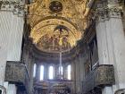 A ceiling of a church; the whole building is covered in painting, statues and wood carvings