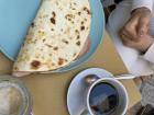 Piadini, a flatbread panini with cheese, ham and pickles